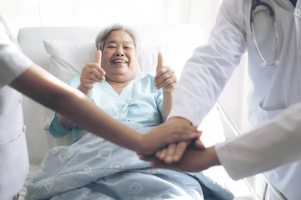 침대에 나이든 아시아 환자가 병원내 최고의 의료진에게 감사를 표하기 앞으로 — 스톡 사진
