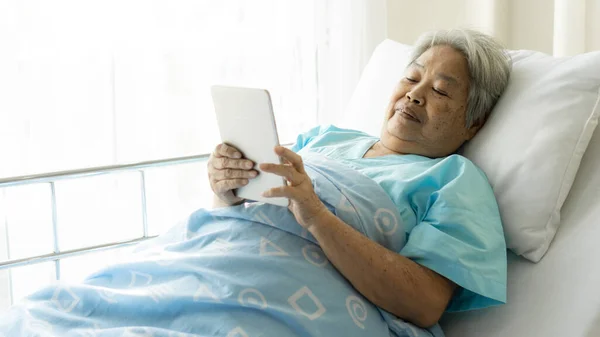 Elderly patients in hospital bed patients using smart phone call to descendant relatives feel happy ness - medical and healthcare concept