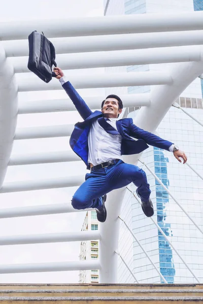 lifestyle business man feel happy jumping in air celebrating  success and achievement  on business district ,  business concept