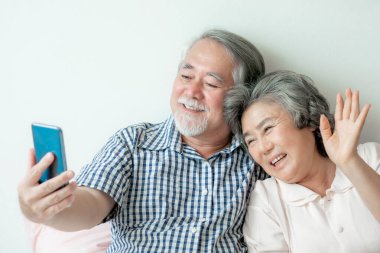 Üst düzey bir çift akıllı telefon kullanıyor. Tek başına fotoğraf çektir, fotoğraf çek, gülümse. Yatak odasında mutlu ol.