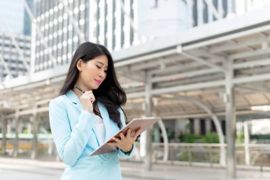 İş kadını kıyafetleri giyen güzel bir kız. İş bölgesi şehir geçmişi, iş konsepti.