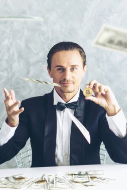 İş adamı zengini tüccar Bitcoin altın sikkesi tutuyor Bitcoin tüccarı için yeni para değişimi ve masa başı iş konsepti üzerine Amerikan doları banknotları