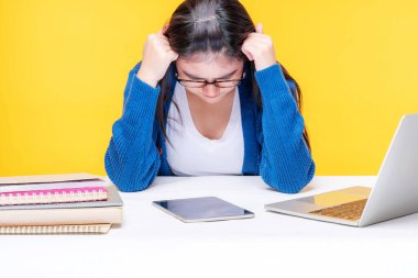 Genç bir kadın evde dizüstü bilgisayar ve not defteriyle çalışırken kendini ciddi hissediyor. İnternette e-öğrenim sistemi okuyor.