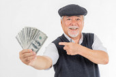 Business senior bohatý muž držící peníze americké dolarové bankovky a ukazující peníze v ruce izolované na bílém pozadí, koncept pro senior úspěch podnikání
