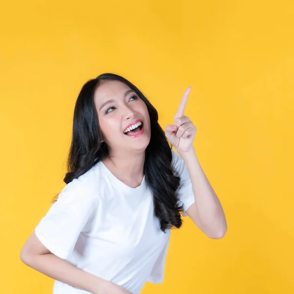 아름다운 아시아 여성이 웃으며 배경에 고립된 광고를 복사본 공간을 손가락으로 — 스톡 사진