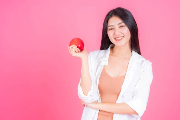 美しいアジアの女性かわいい女の子はコピースペースでピンクの背景に隔離された健康のための幸せな保持赤いリンゴの果実を感じる ライフスタイルの健康的な女性のコンセプト — ストック写真