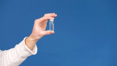 Şişeli bir elin stüdyo fotoğrafı.