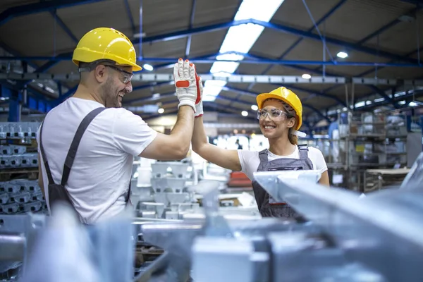 Fabrika işçileri başarılı takım çalışmalarından dolayı birbirlerini selamlıyorlar..