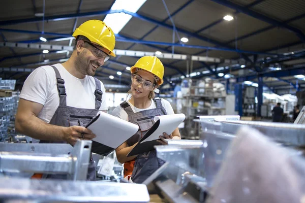 Operai Che Analizzano Risultati Della Produzione Nel Grande Capannone Industriale — Foto Stock