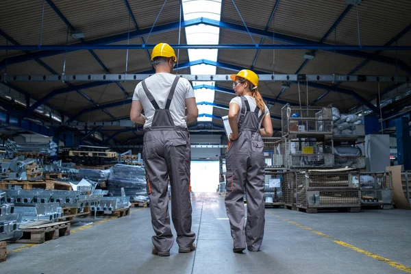 大規模な生産ホールを歩いて会話をする工場労働者 — ストック写真