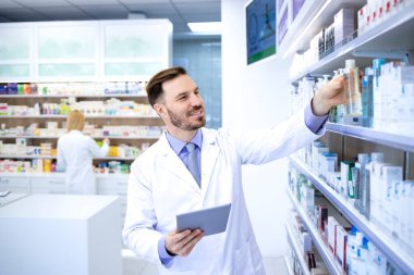 Eczanede ya da eczanede çalışan profesyonel yakışıklı bir eczacı. Raftan ilaç alıyordum. Sağlık ve eczacı.