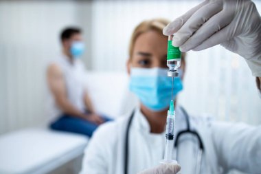 Corona virüsü salgını sırasında hastaya aşı aşısı hazırlayan doktoru yakından izleyin..