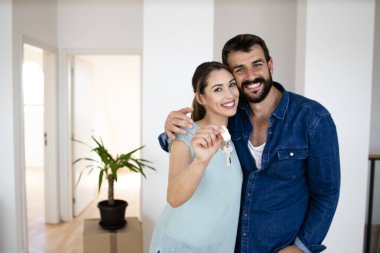 Portrait of happy smiling family holding keys of their new house.