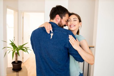 Young caucasian couple celebrating moving day in new house.