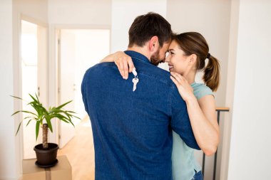 Happy young couple dancing and celebrating moving day in their new home.