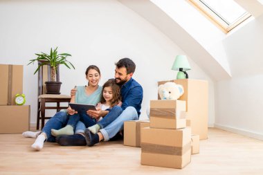 House moving concept - happy family choosing house interior design on tablet computer.