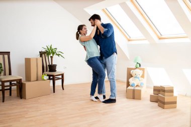 Happy young couple dancing and celebrating moving into new house.