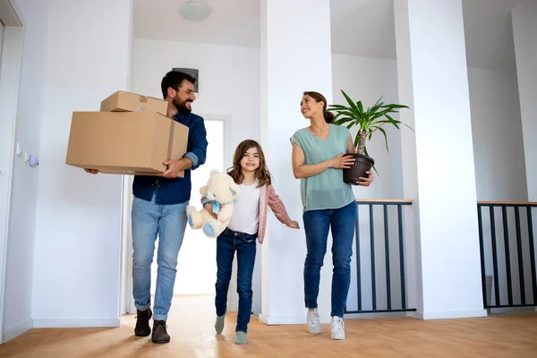 Young Happy Family Holding Boxes Flower While Moving New Home —  Fotos de Stock