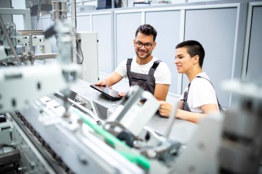 Deneyimli servis elemanı kontrol süreci ve üretim fabrikasındaki modern endüstriyel üretim makinesine hizmet.