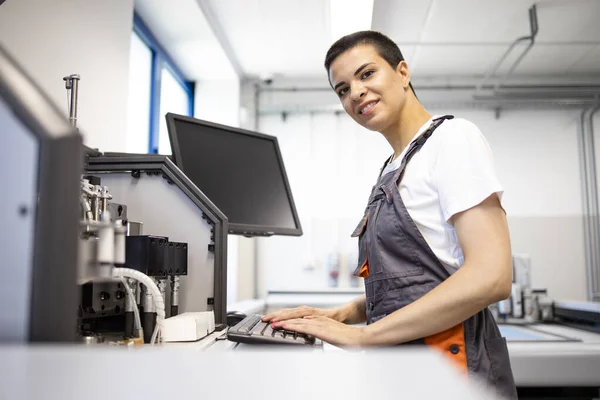 産業生産機械に立つ笑顔の女性労働者の肖像 — ストック写真