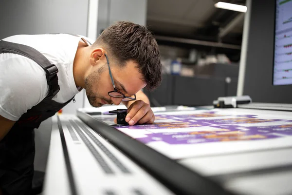現代の印刷所でグラフィックの印刷品質をチェック労働者 — ストック写真