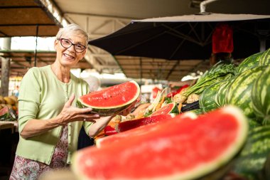 Sağlıklı beslenmek için marketten taze organik karpuz alan yaşlı kadın portresi.