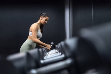 Gerizekalı halter çalışması. Spor salonunda kaslarını çalıştıran güçlü bir fitness kadını..