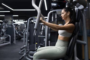 Spor salonundaki spor makinesinde spor yapan kadın..