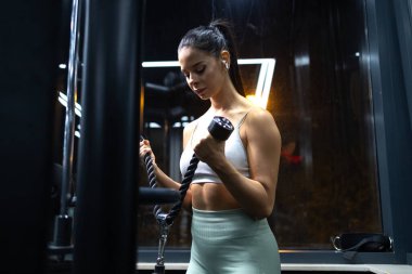 Spor salonundaki makinede egzersiz yapan motive olmuş profesyonel bir sporcu..