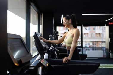 İyi donanımlı spor salonunda koşu bandında koşan kadın sporcu ya da stajyer..