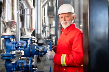 Petrol rafinerisi veya petrokimya fabrikasında valfleri denetleyen kıdemli işçiler