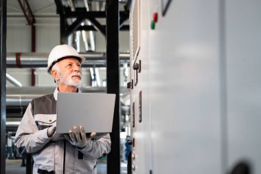 Deneyimli endüstriyel işçi dizüstü bilgisayar izleme fabrikası operasyonlarını yürütüyor