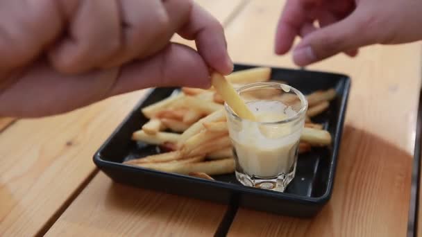 Hand takes french fries with cheese dip — Stock Video
