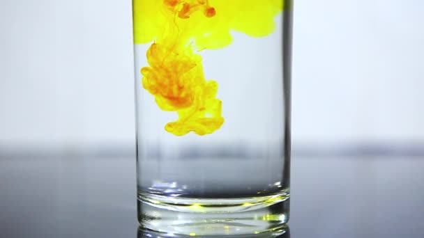 Drop gele inkt water in glas. Slow motion — Stockvideo