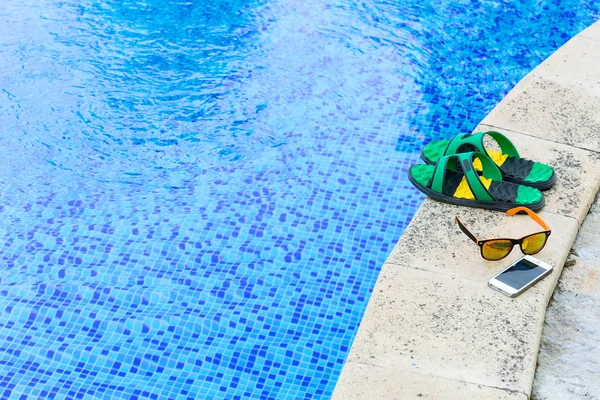 Sandálias por uma piscina — Fotografia de Stock