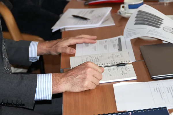 Mannenhand aan de onderhandelingstafel Stockfoto