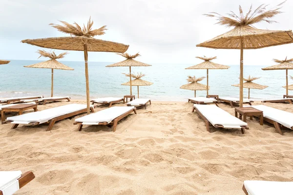 Ombrelli di paglia sulla spiaggia soleggiata in Bulgaria — Foto Stock