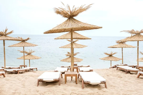 Stro paraplu's op zonnige strand in Bulgarije Stockfoto