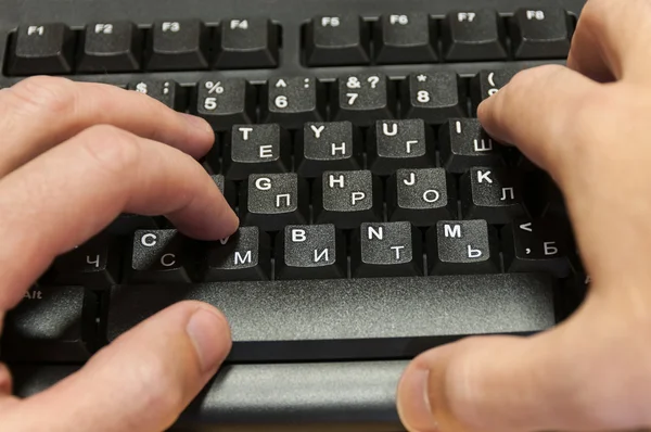 Mani di uomo digitando su una tastiera — Foto Stock