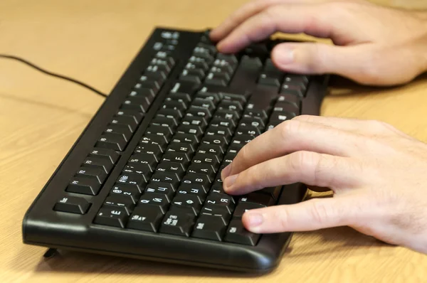 Mani di uomo digitando su una tastiera — Foto Stock