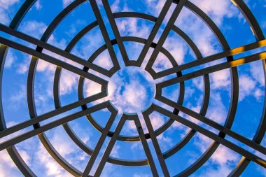 Balkon çatısının kubbesinden bulutlu açık mavi gökyüzünü görebilirsin..