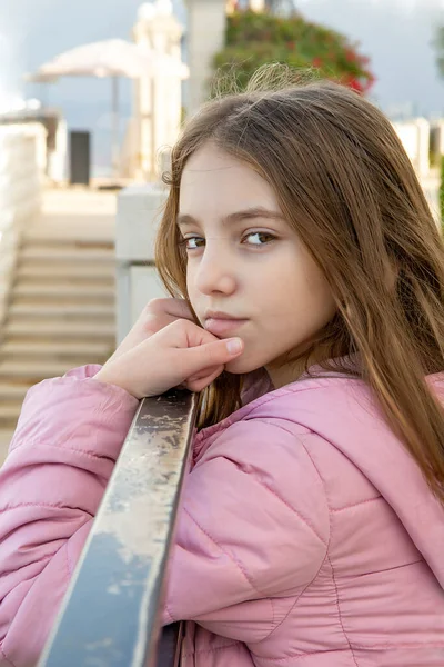 teenage girl in a lilac jacket against the background of the city of haifa, the Bahai Garden