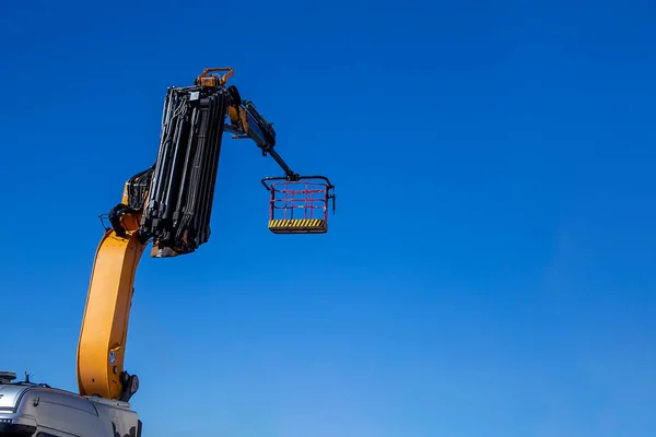 crane basket, elevating platform against clear sky, space for te