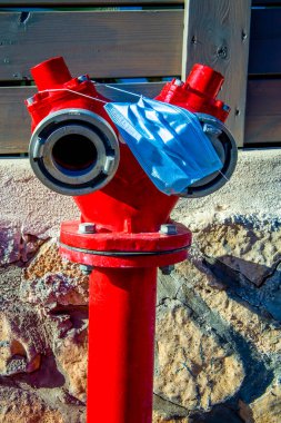 Kırmızı muslukta tıbbi mavi maske var. Covid-19 'a karşı koruma maskesi. Covid-19 'un sonuçları.