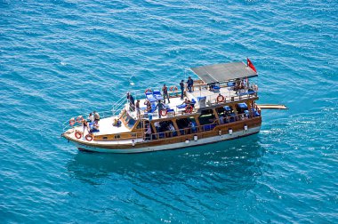 Antalya, Türkiye - 19 Nisan 2009: Yukarıdan çekilen, mavi denizde yüzen insanlarla dolu bir tekne
