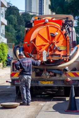 Hayfa, İsrail, 25 Ocak 2021: Açık bir kapaktan kanalizasyon bakımı yapan özel bir araç var