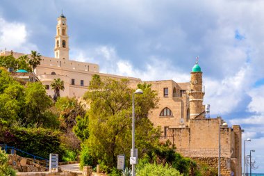 Tel Aviv-Jaffo, İsrail - 4 Mart 2021: St. Peter Kilisesi 'nin manzarası, Aziz Peter Kilisesi' nin çan kulesi ve el-Bahr Camii veya İsrail 'in Tel Aviv Yaffo kentindeki Eski Jaffa' daki Deniz Camii