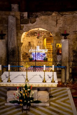 Nasıra, İsrail - 08 Nisan 2021: ızgaranın içinden bir mum ve Nazaret 'in merkezindeki Annunciation Kilisesi Bazilikası' ndaki Marie Icon