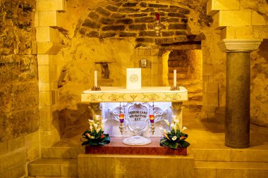 Nasıra, İsrail - 08 Nisan 2021: ızgaranın içinden bir mum ve Nazaret 'in merkezindeki Annunciation Kilisesi Bazilikası' ndaki Marie Icon