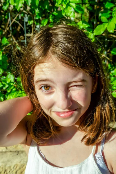 Beautiful emotional natural cute teenager girl looking at camera. Trendy girl in casual summer clothes winking. Positive female emotion facial expression body language. Funny model — Stock Image Beautiful Emotional Natural Cute Teenager Girl Looking Camera Trendy Girl Royalty Free Stock Images